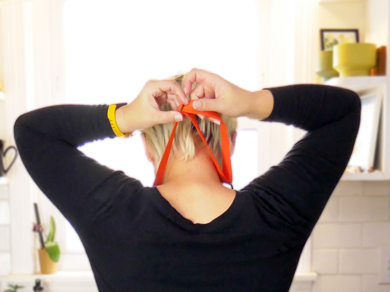 a person adjusting the neck part of an apron