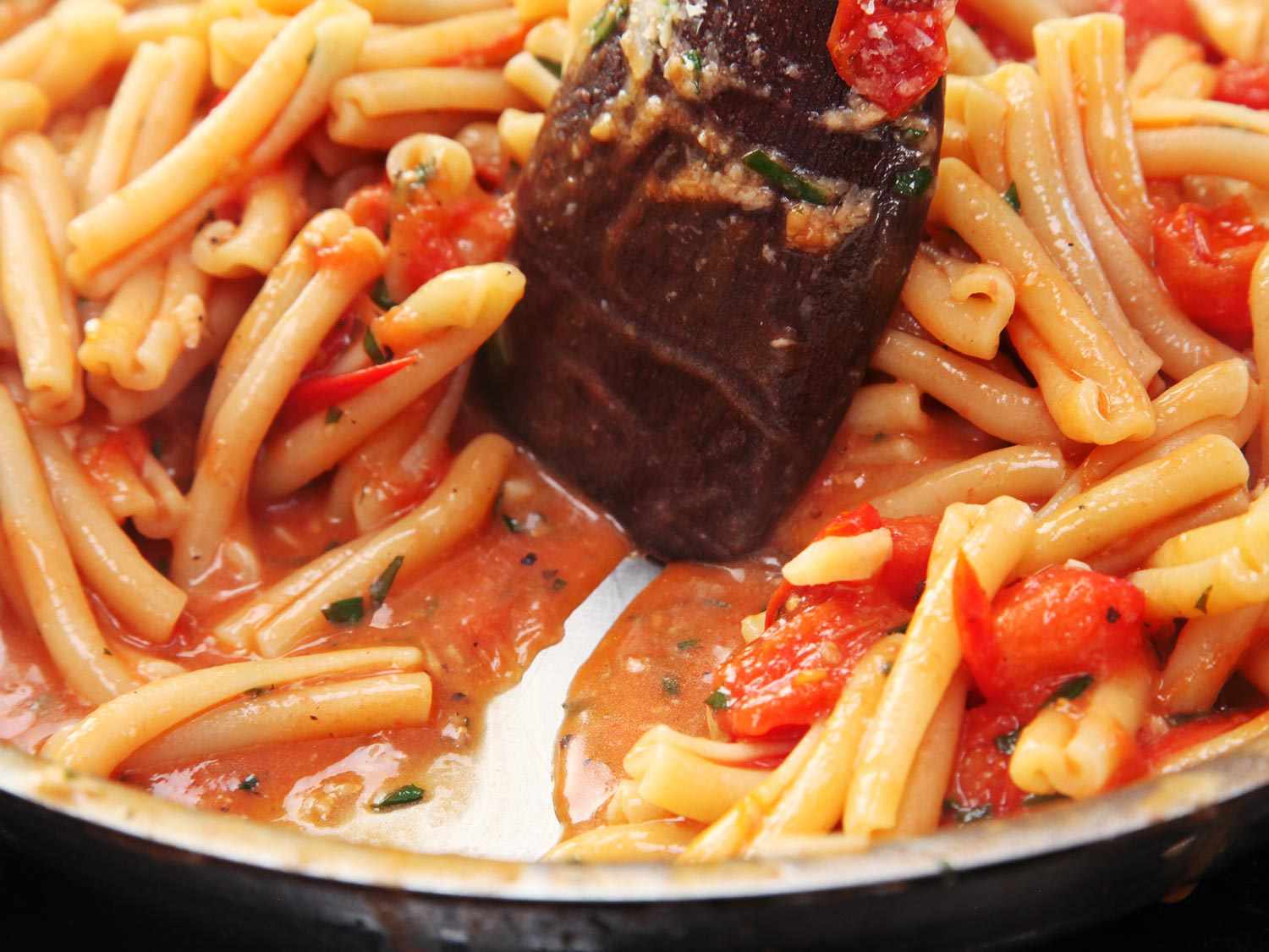 A pan of pasta in cherry tomato sauce. 