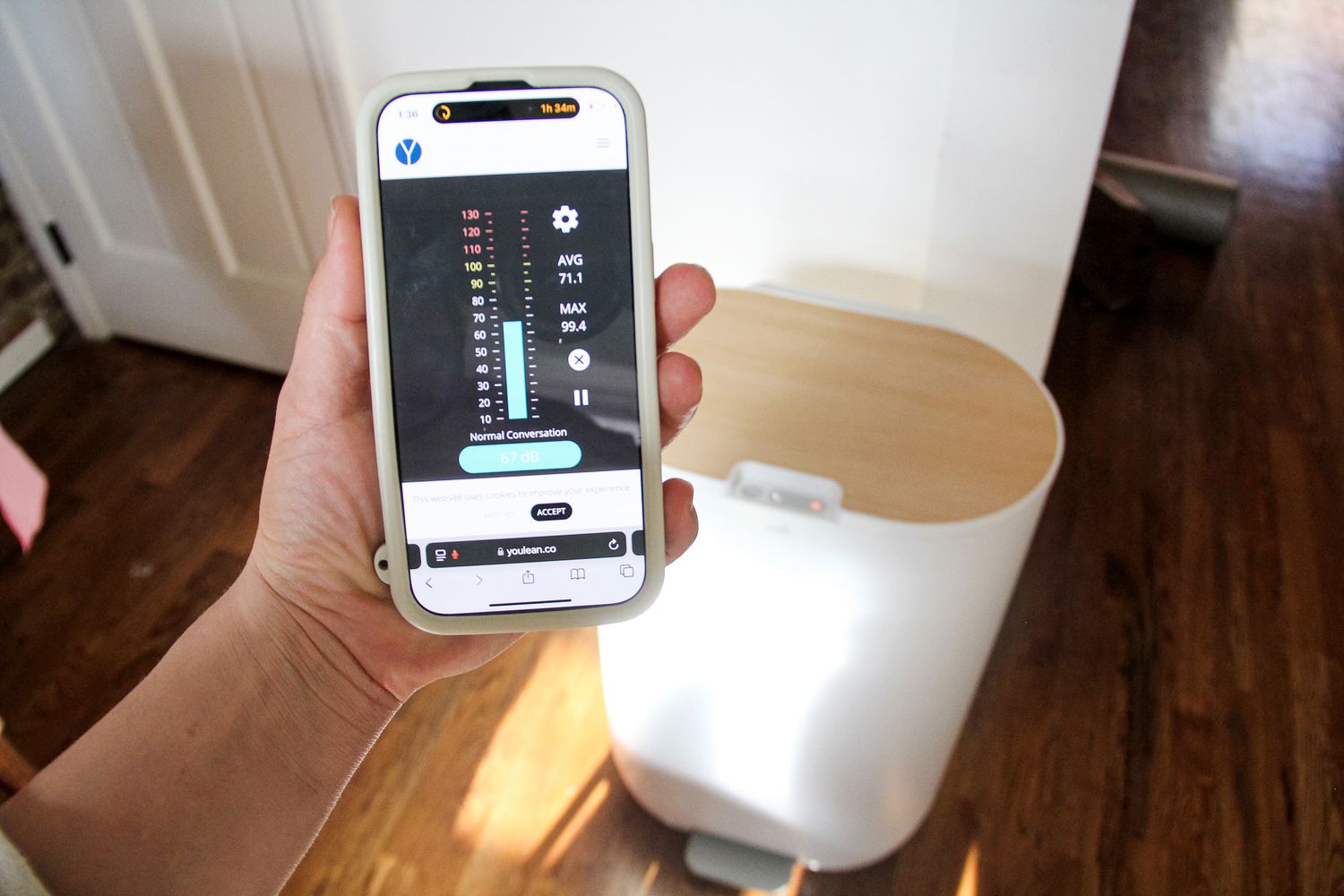 A person holding the MIll's app in front of the Mill FoodCycler. 