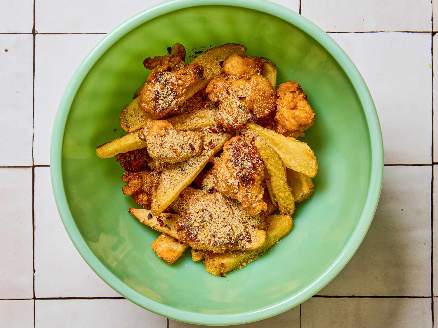A bowl containing fried food items including potato wedges and other deepfried pieces