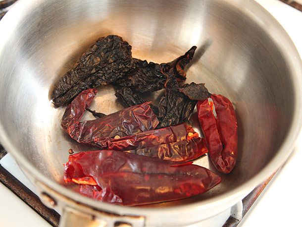 Dried ancho and guajillo chiles in a stainless steel sauce pan