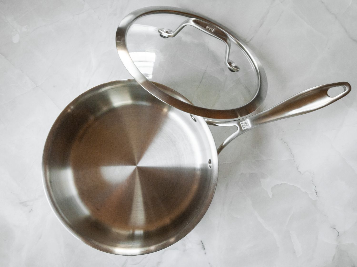 The Zwilling saucepan and its lid on a marble countertop.