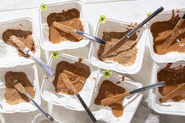 Assorted samples of almond butter in containers with small spreading knives
