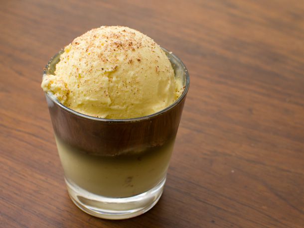 A scoop of eggnog ice cream garnished with grated nutmeg.