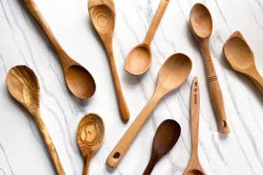 Various wooden spoons arranged on a marble surface