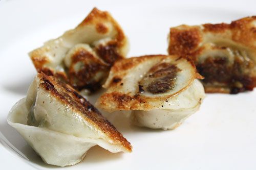 Seared wontons on a white plate.
