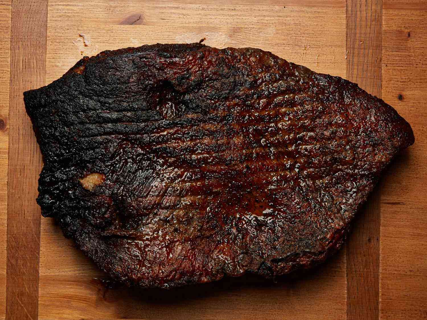 Smoked brisket displayed on a wooden surface