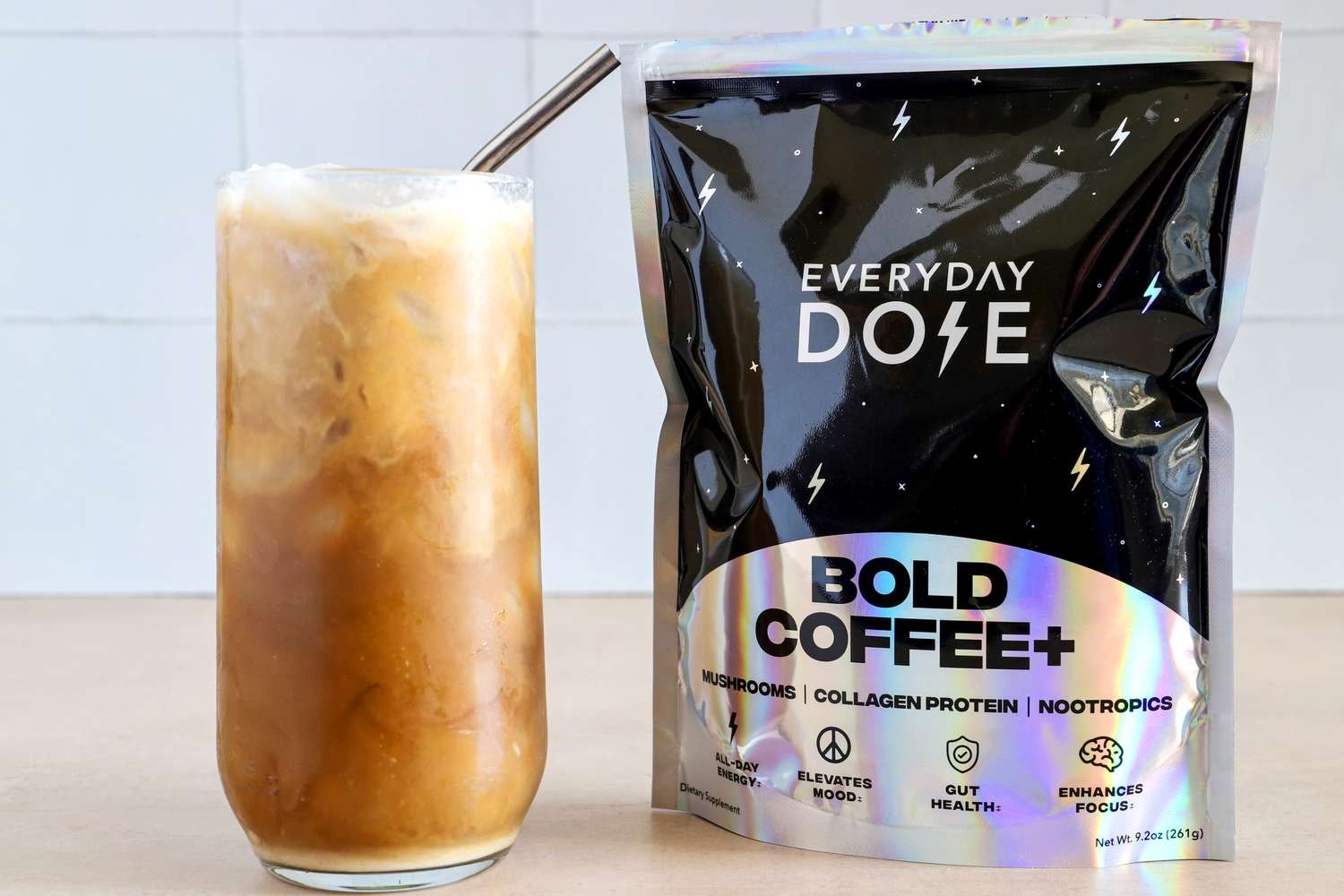 A glass of iced coffee next to a package labeled 'Everyday Dose Bold Coffee+' with benefits mentioned