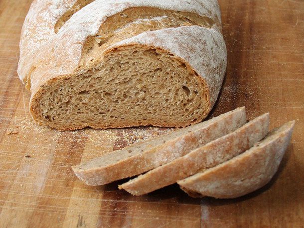 Rye bread with molasses and caraway is sliced on a cutting board.
