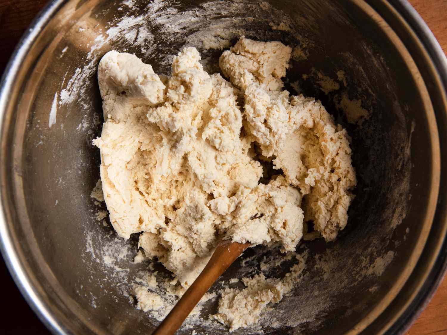 Stirring cream into dry ingredients with a wooden spoon