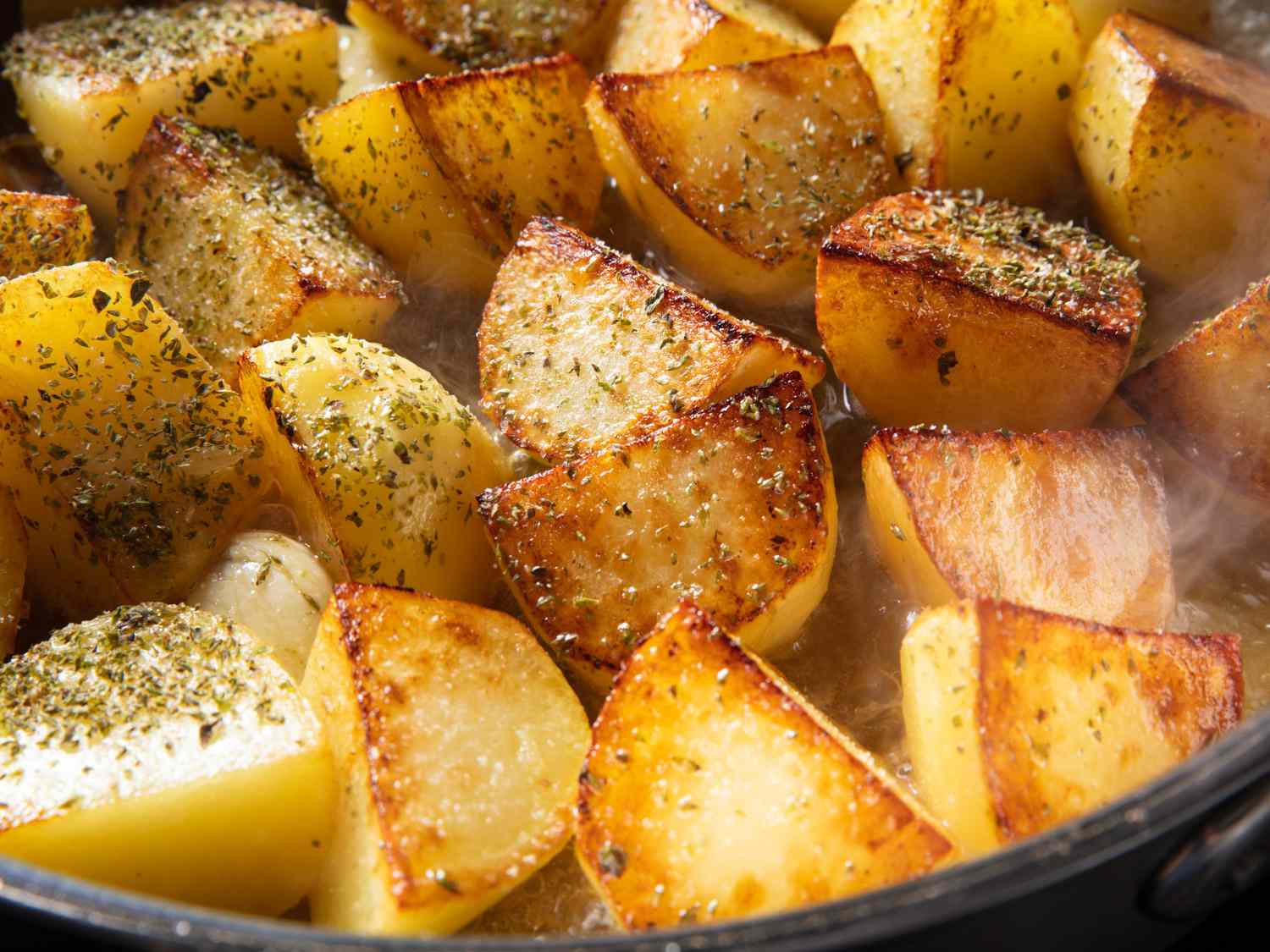 Closeup of lemon potatoes in a skillet before going into the oven