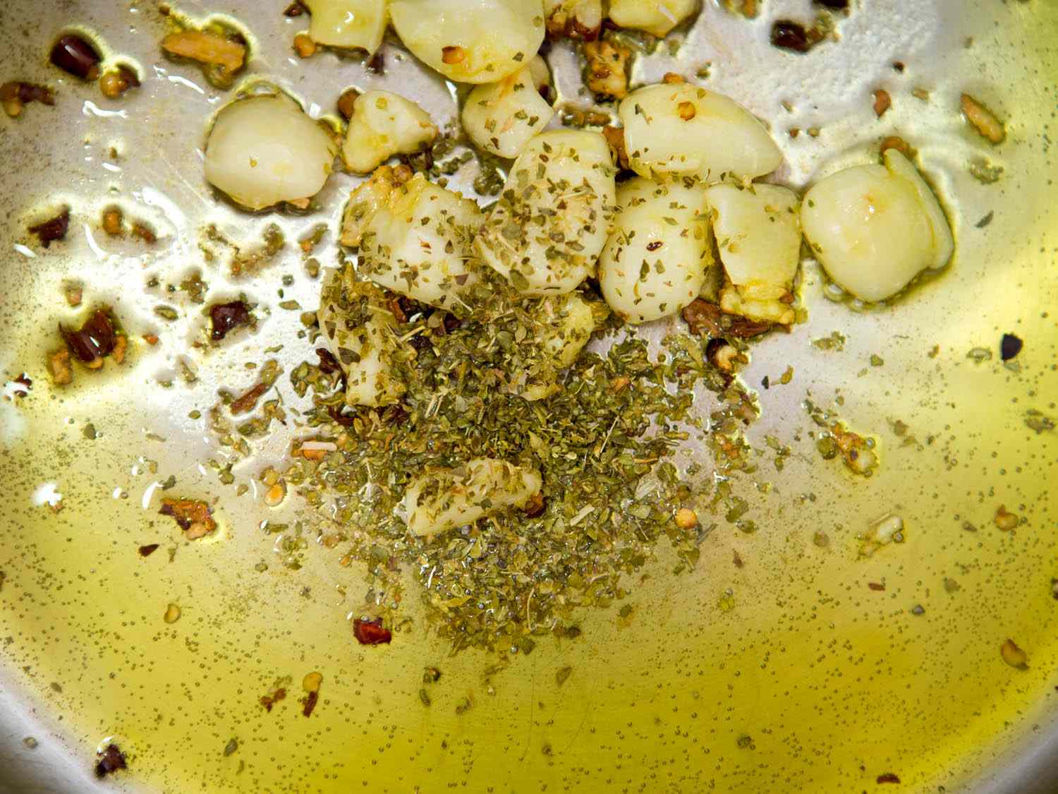 Sautéing garlic, red pepper flakes, and oregano in olive oil for quick Italian-American red sauce.