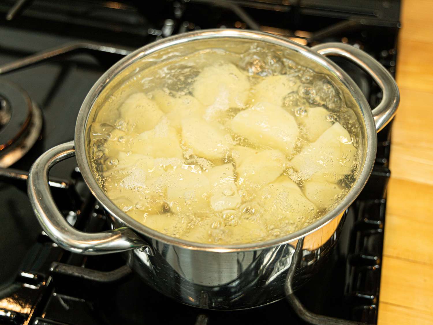 Side view of potatoes boiling in water