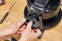 A person locks the Black+Decker Double Flip Rotating Waffle Maker