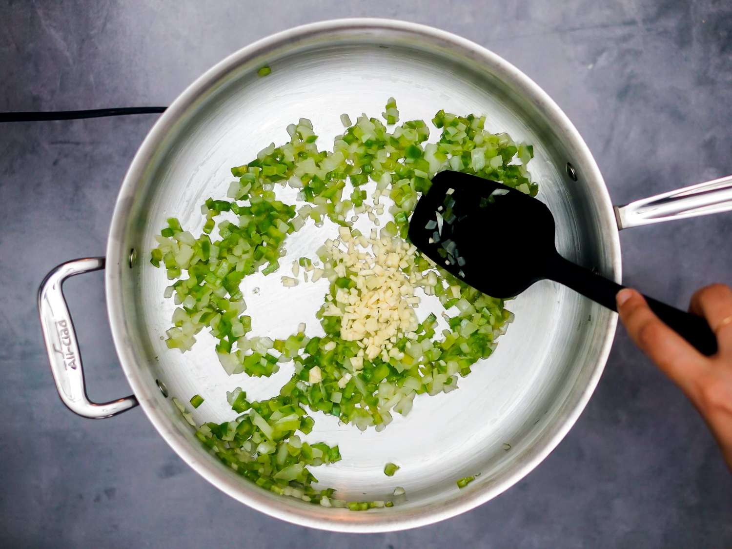 Onions, celery, bell pepper, and garlic added to pan