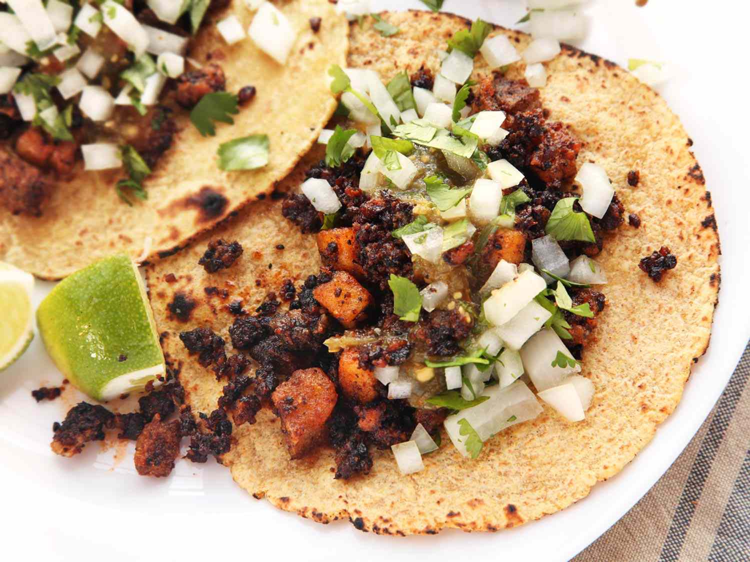 Close-up of a vegan chorizo taco. The filling has been fried and looks well browned.