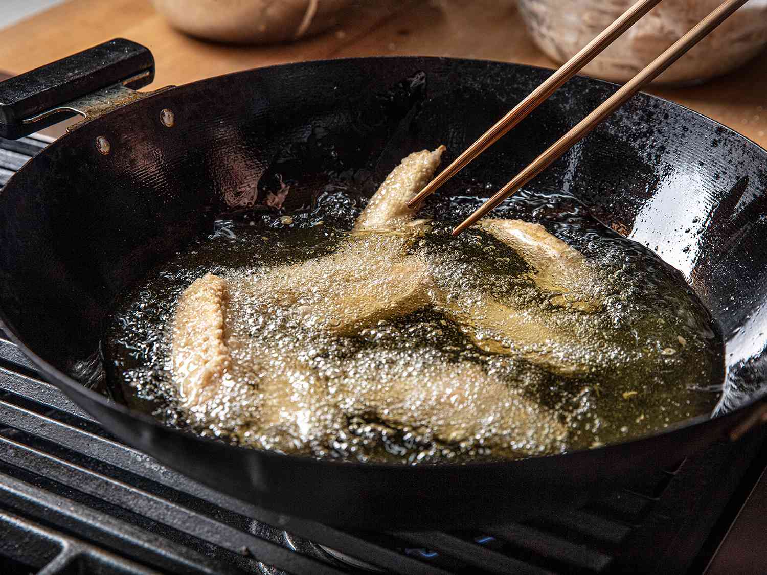 Chicken being deep-fried in a wok