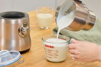 Pouring milk from the Breville's pitcher into a measuring cup.
