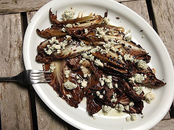 Overhead view of a platter of grilled trevisano with gorgonzola, olive oil, and saba.