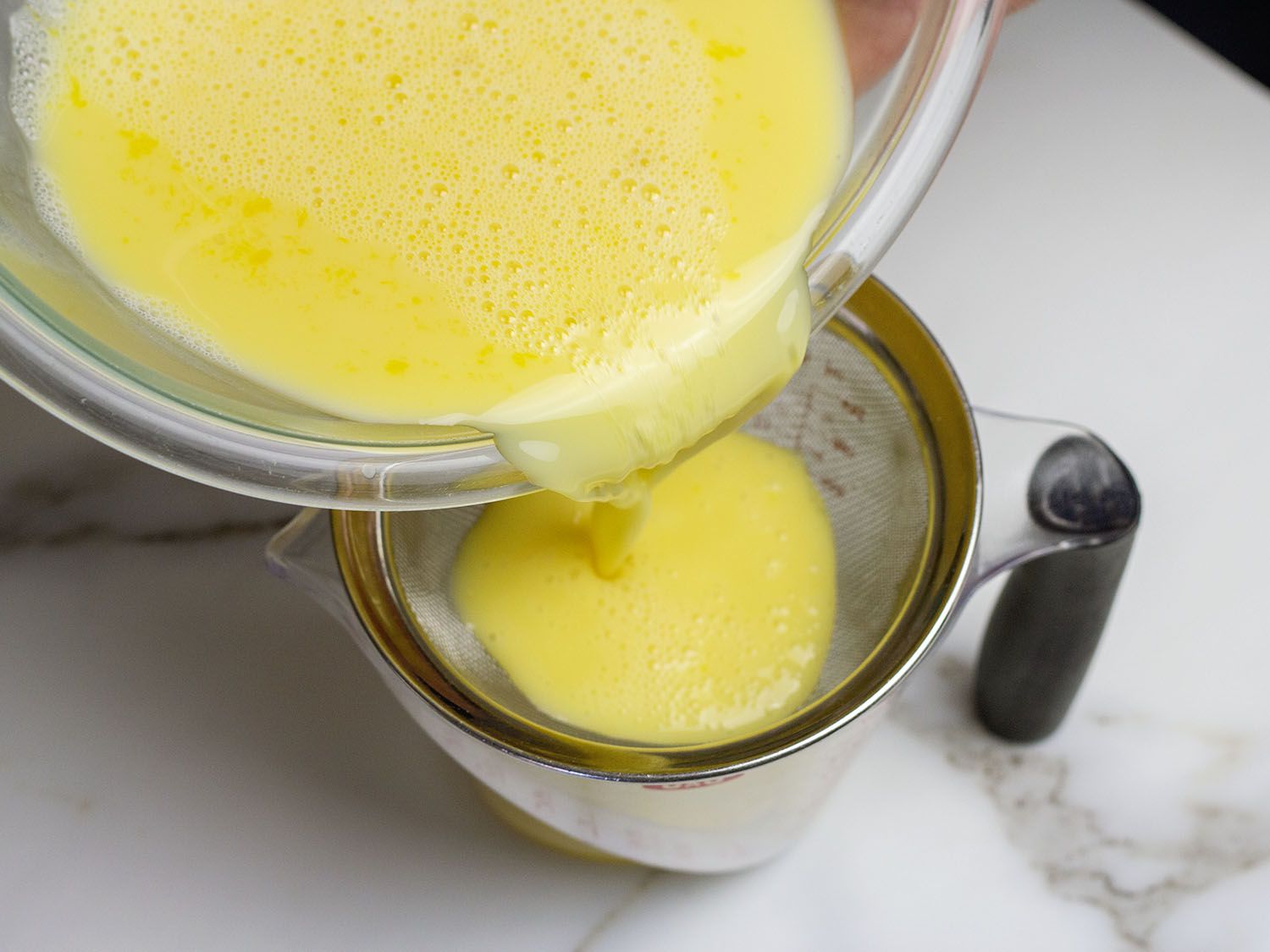 Hong Kong egg custard tart egg custard mixture being strained into measuring cup