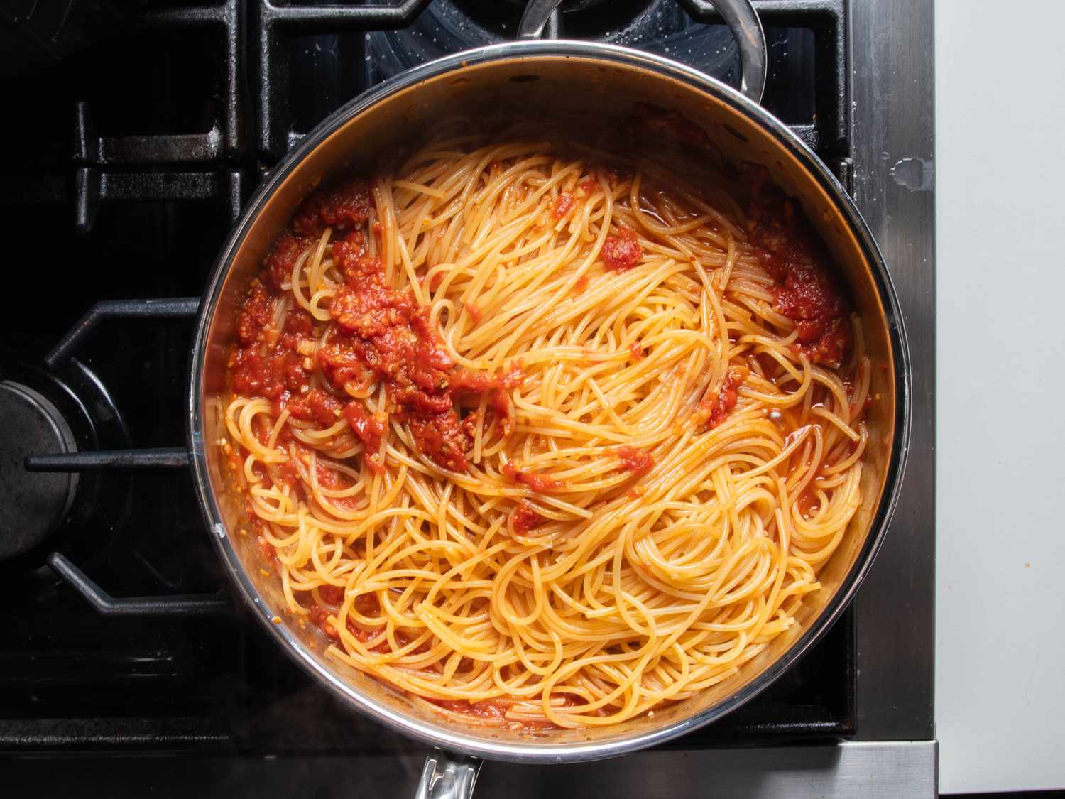 Spaghetti in the pan with the lobster-tomato sauce.