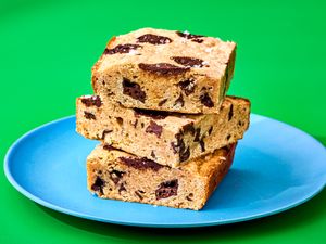 Three banana bread blondies stacked on a blue plate