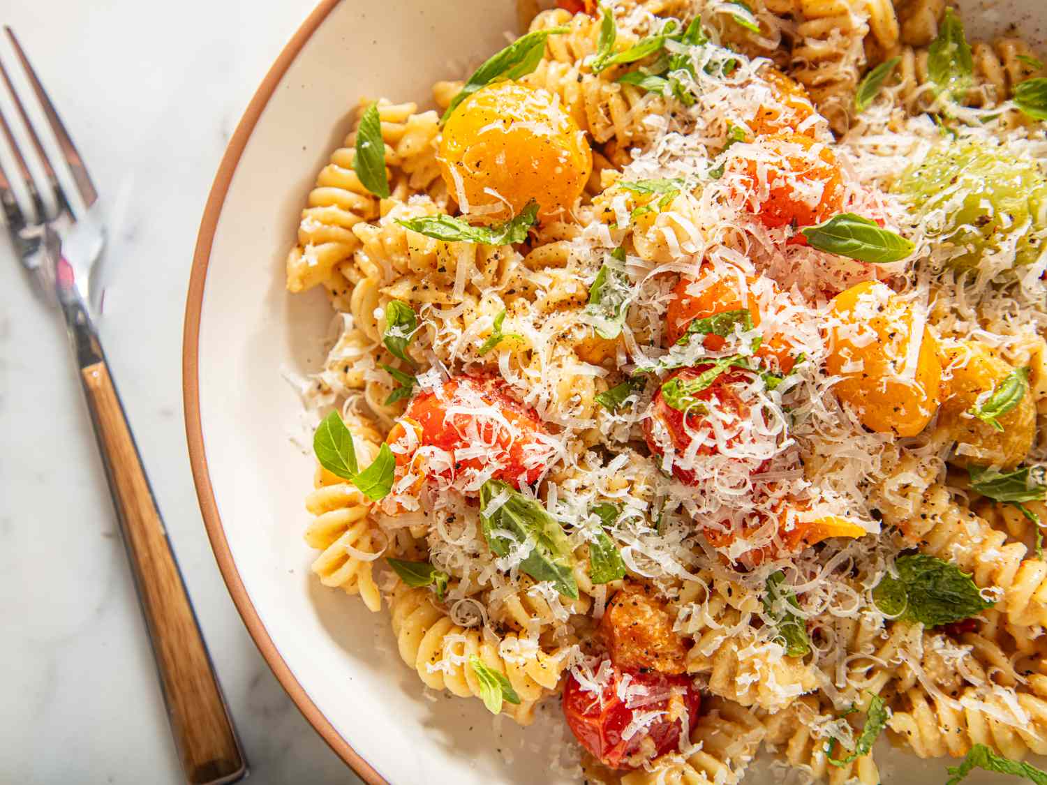 Bowl of pasta with roasted vegetables and grated cheese