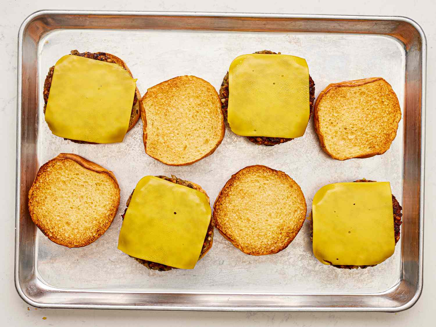 Overhead view of patties transferred to toasted buns