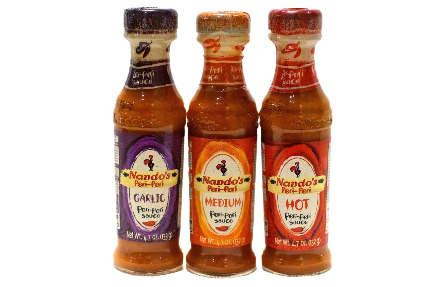 Bottles of garlic, medium, and hot peri-peri sauces.