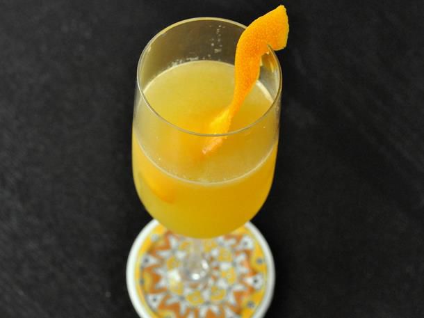 A Cara-Carry Me Away cocktail, served in a stemware glass with an orange twist.