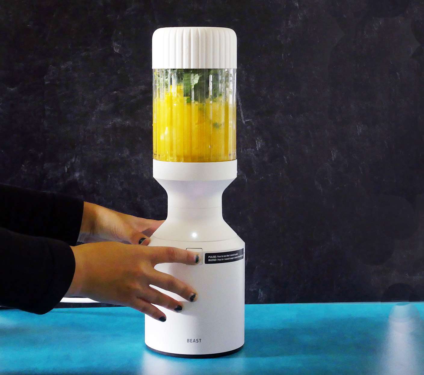 blending orange juice, kale, and frozen mango and banana in the beast blender