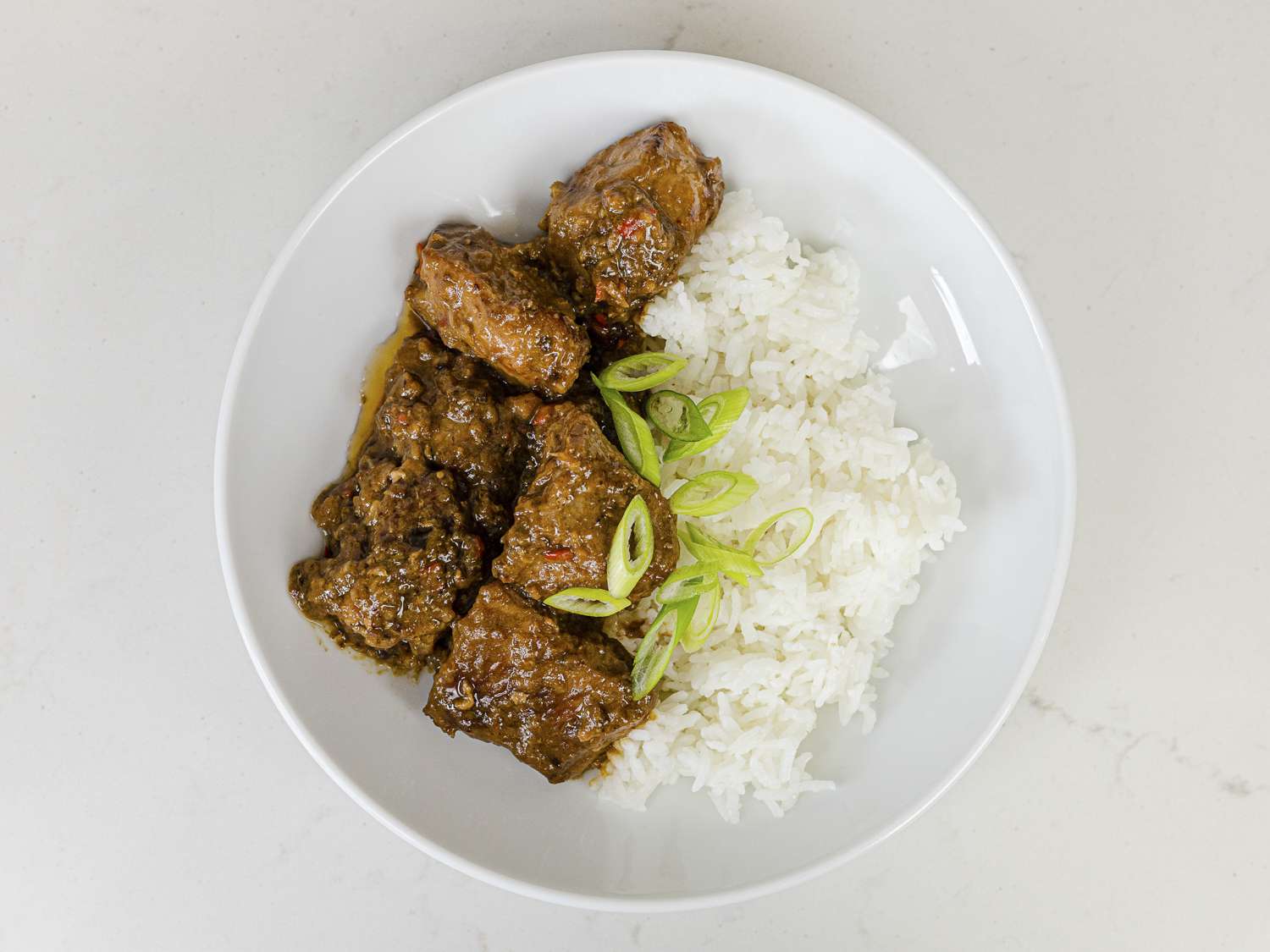 Bikol Express plated on a white plate with white rice