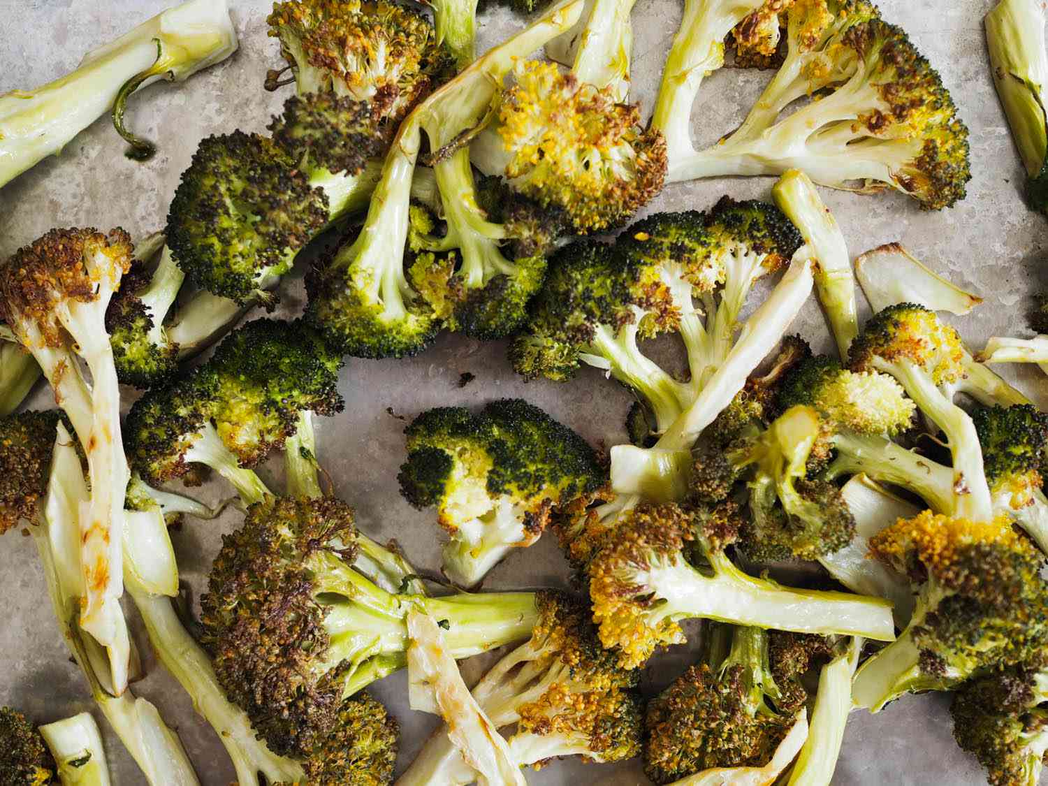 Closeup of roasted broccoli on a sheet pan.