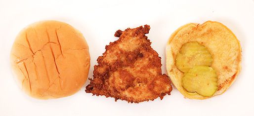 A Chick-fil-A chicken sandwich opened up to show top bun, piece of fried chicken breast, and bottom bun with two pickles.
