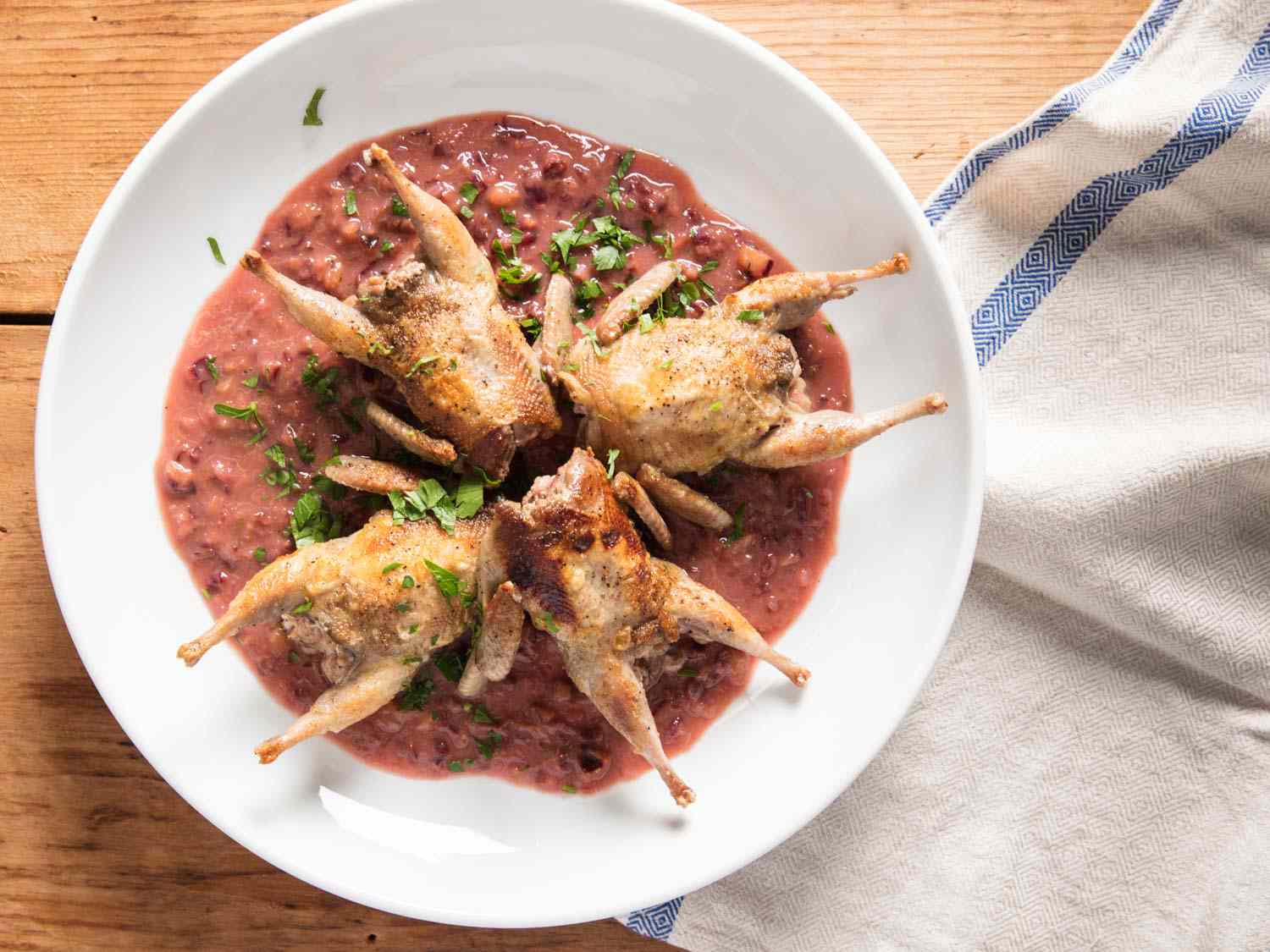 Overhead view of the finished dish, with the quail neslted atop the sauce.