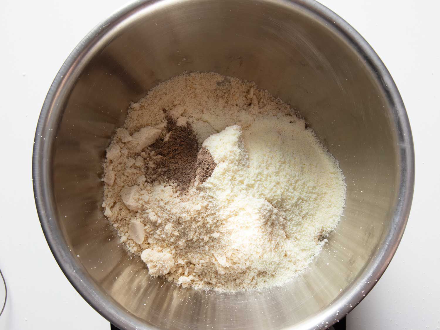 Overhead view of a mixing bowl containing the ground cashew mixture.
