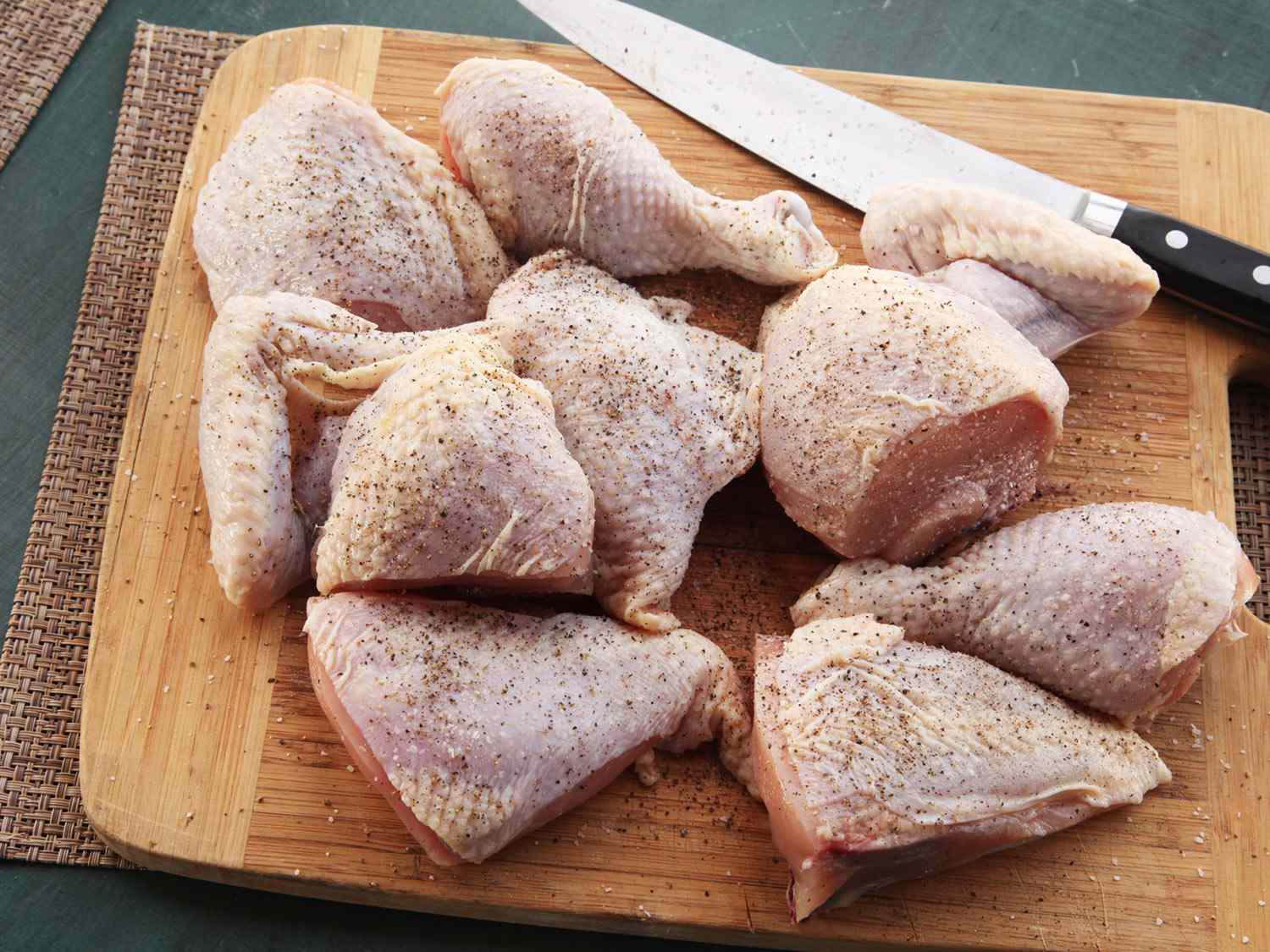 Raw chicken pieces seasoned with salt and pepper for roasting