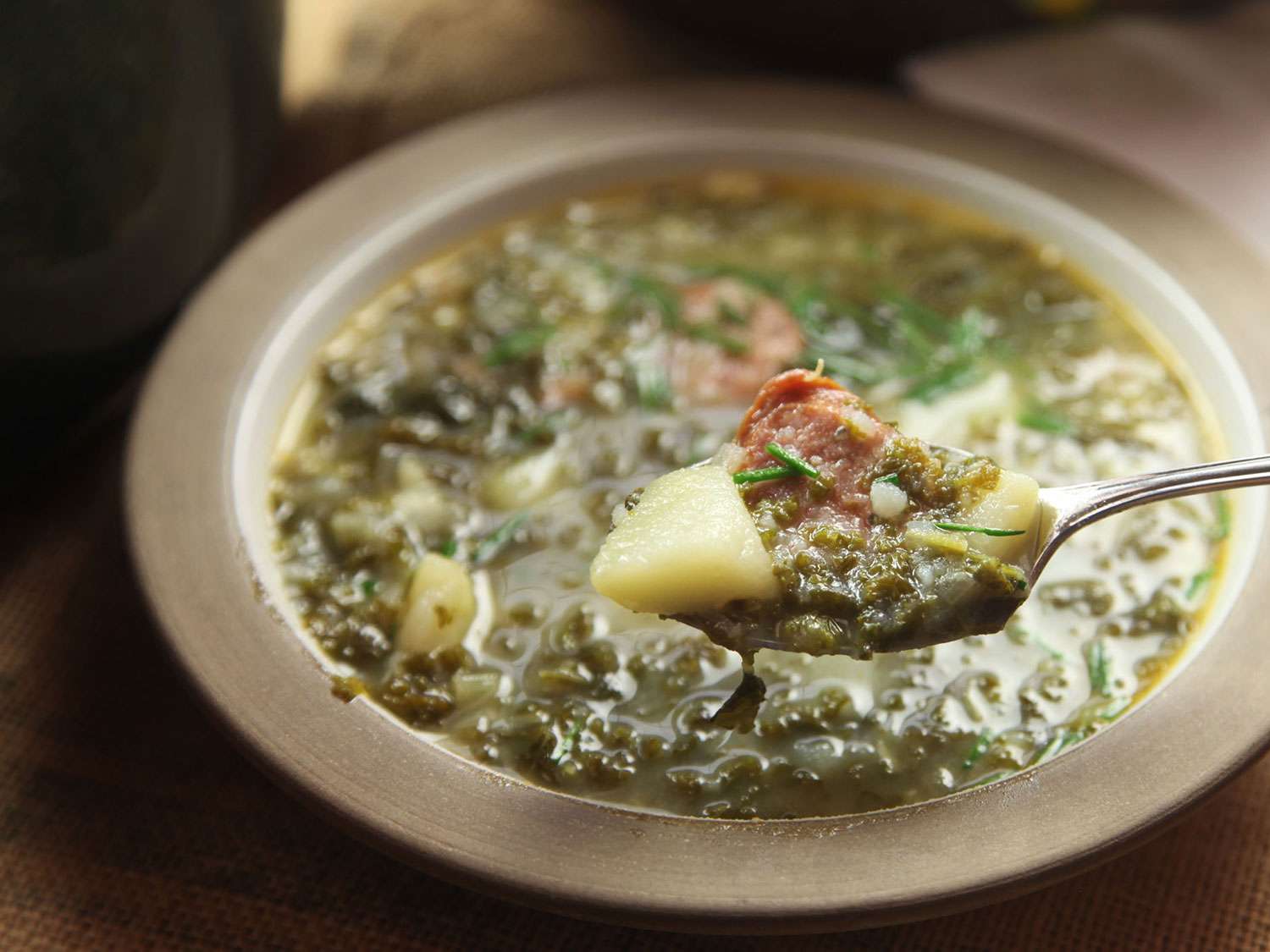 A spoonful from a bowl of Portuguese caldo verde.