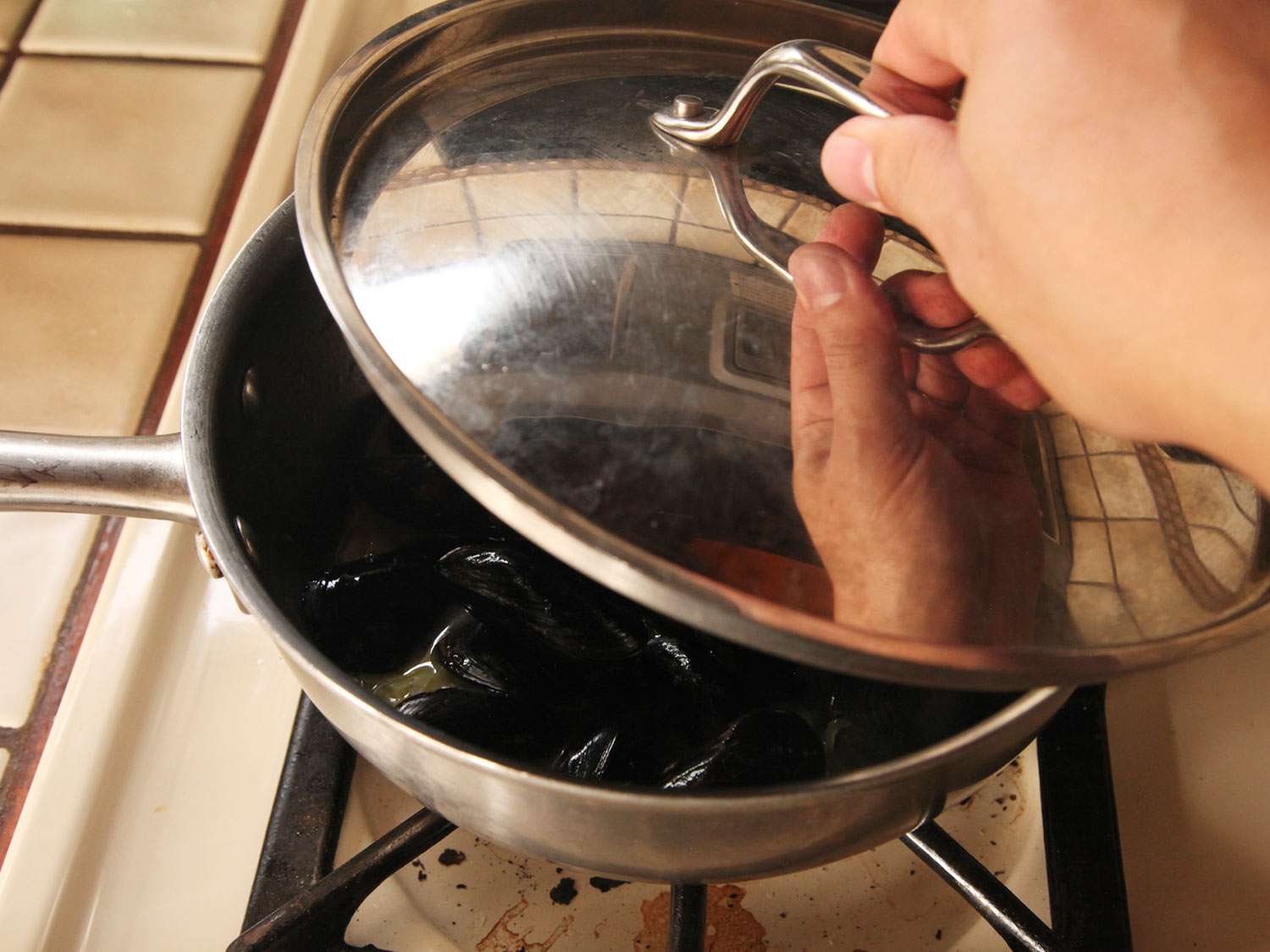 Author placing lid on pan of mussels.