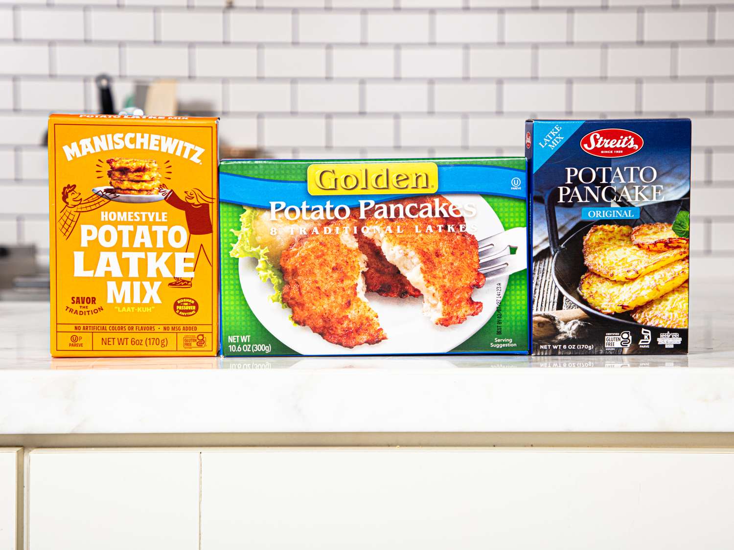 Three boxes of potato latke mix displayed on a countertop in a kitchen setting