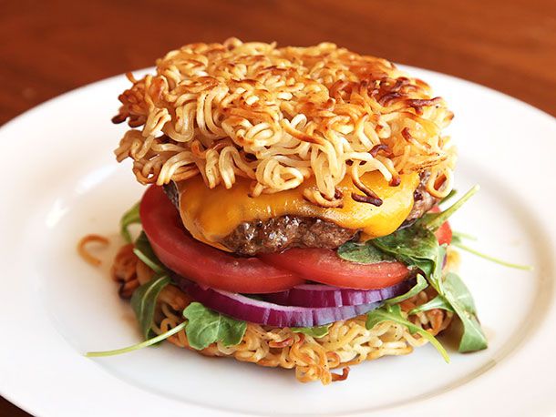 Cheeseburger with baby greens and sliced tomato and red onion, sandwiched between two pan-fried ramen "buns". 