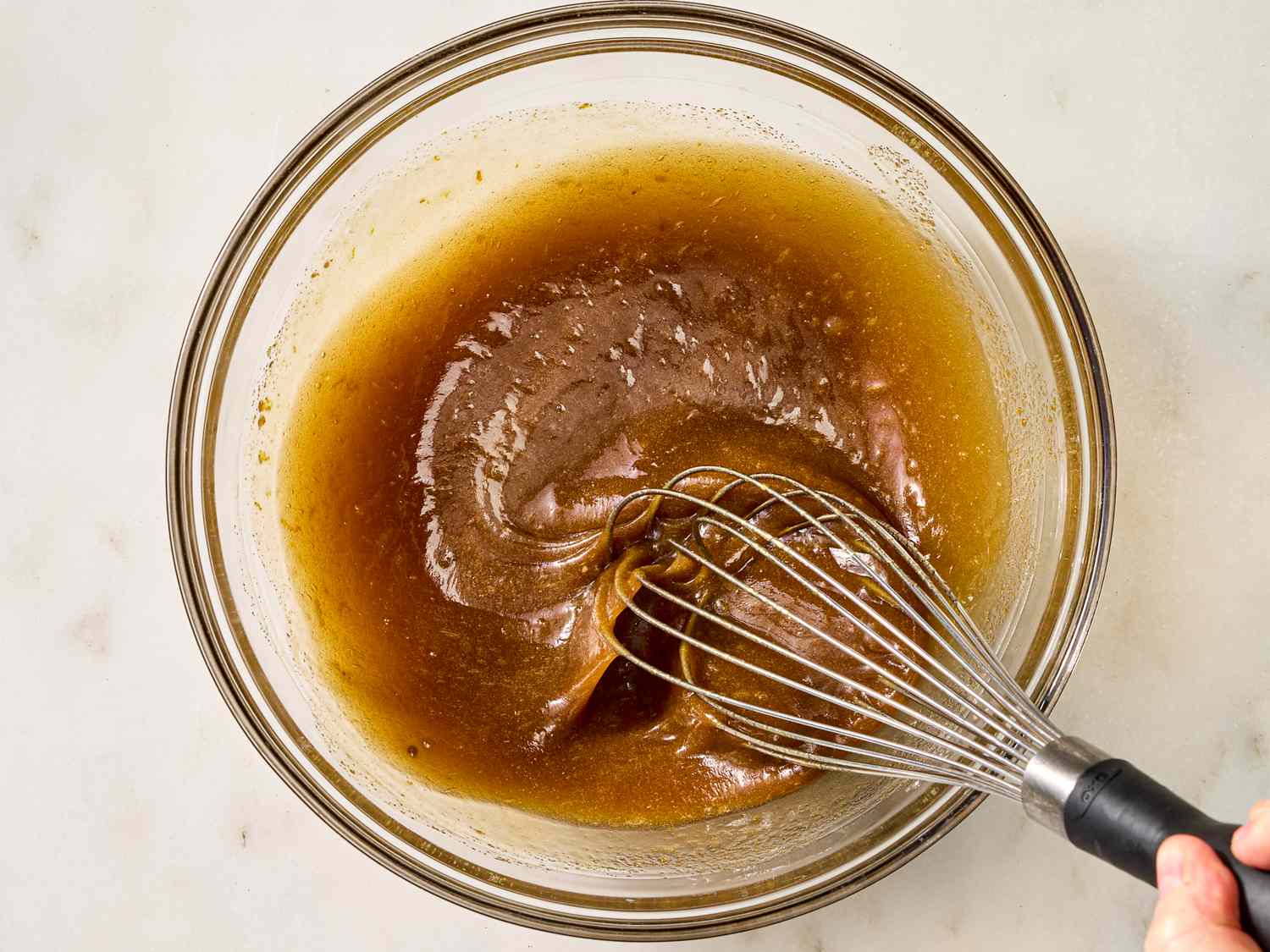 Whisking together sugar, maple syrup, butter, bourbon, vanilla, egg, zest, and salt together in a medium bowl