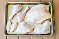 Various raw Butcherbox chicken cuts placed on a rectangular baking tray
