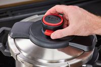 A person unlocks the lid of the T-Fal Clipso Pressure Cooker