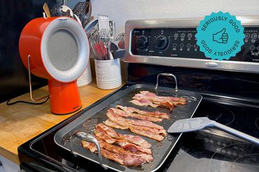 the airhood next to a griddle of bacon on the stove