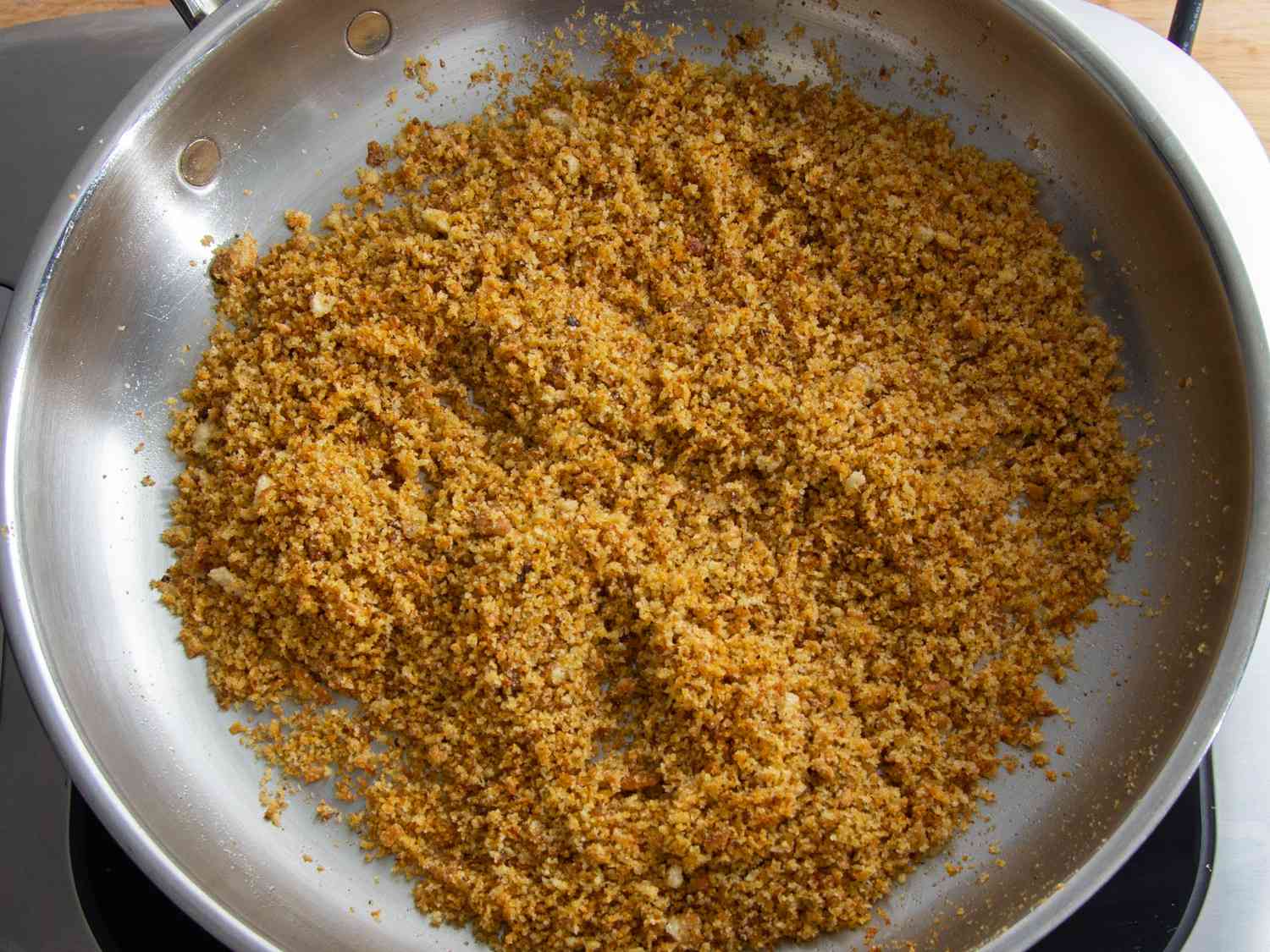 Golden brown breadcrumbs toasted in a frying pan with garlic and olive oil.