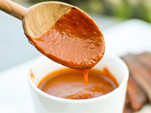 Memphis-style barbecue sauce drips from a wooden spoon.