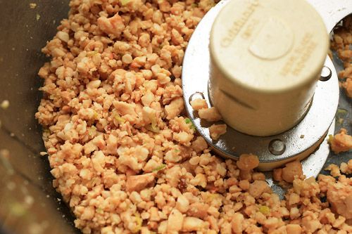 Ground up nuts inside of a food processor.