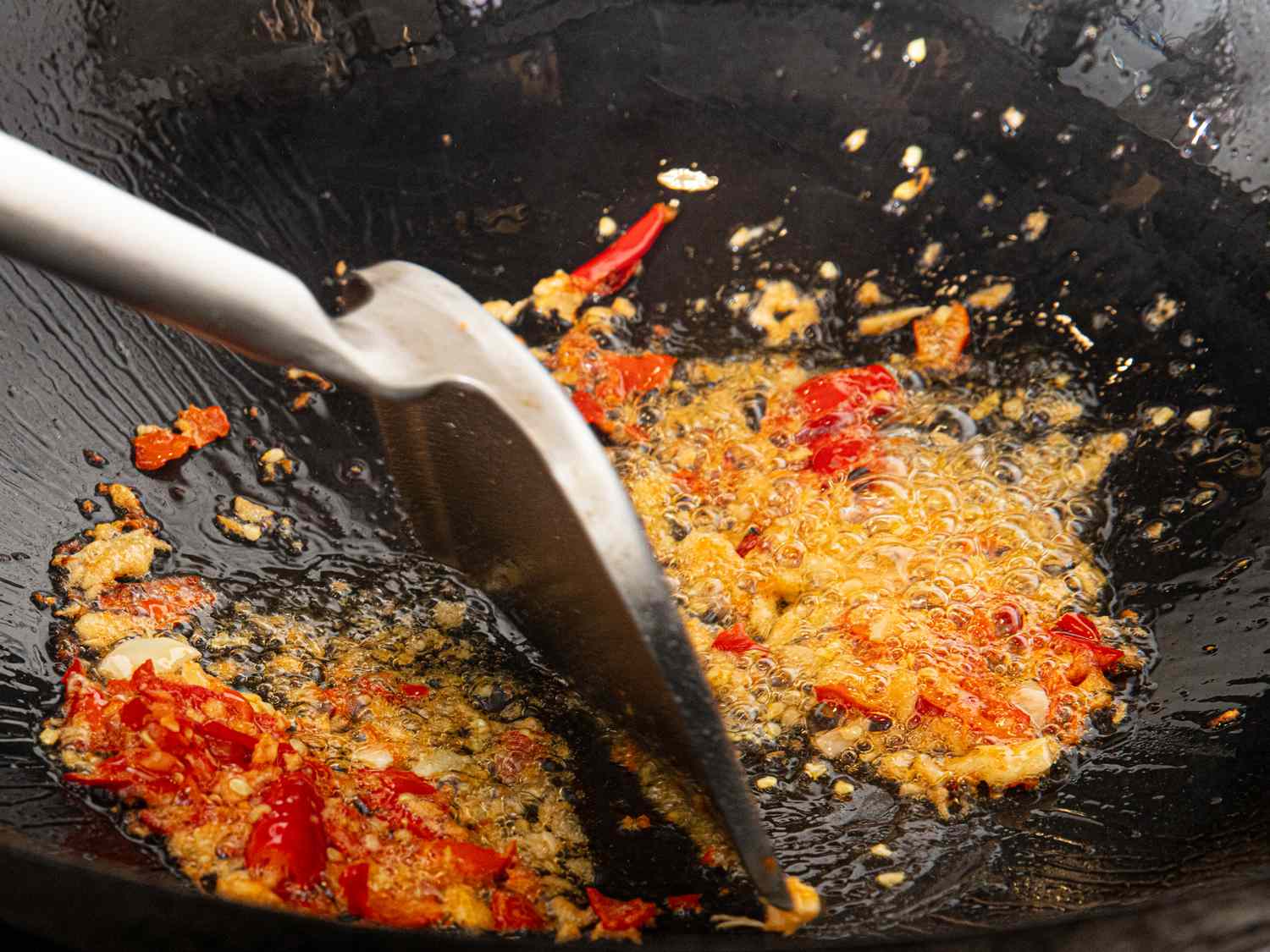 Overhead view of frying pepper and garlic mixture in wok
