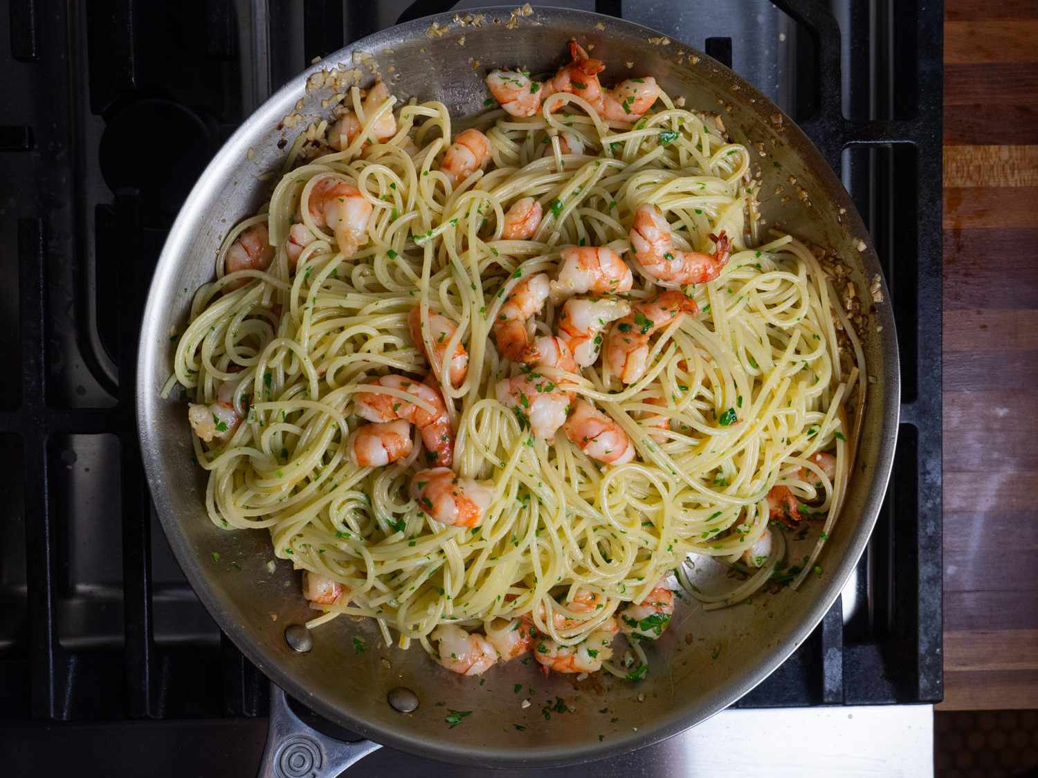 The cooked shrimp added to the spaghetti and sauce in the skillet.